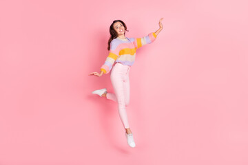 Full length body size view of pretty skinny cheerful girl jumping dancing having fun isolated over pink pastel color background