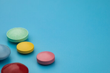 Multicolored tablets on blue background. Health care concept.