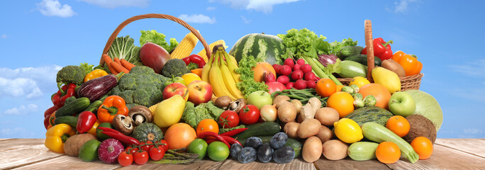 Assortment of fresh organic fruits and vegetables on wooden table outdoors. Banner design