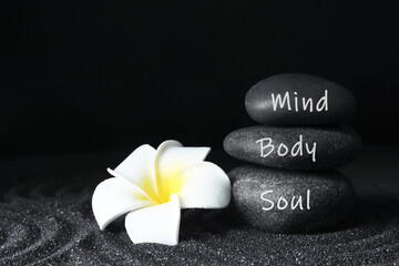 Stones with words Mind, Body, Soul and plumeria flower on sand. Zen lifestyle