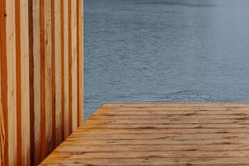 part of wooden landing stage with wall of wooden boat house over water