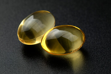 Omega 3 capsules on black background. Health care concept.