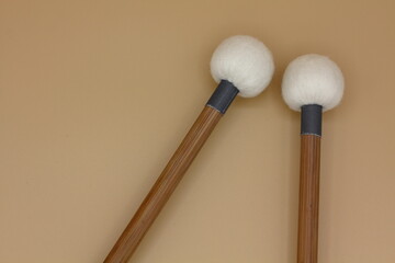 Detail of timpani mallets on a cream background.