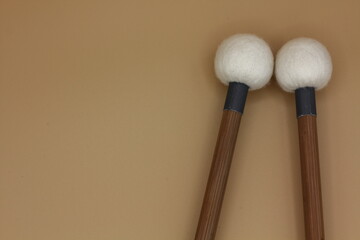Timpani mallets on the right side on a cream background, with space box.
