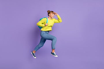 Fototapeta na wymiar Full size profile photo of optimistic blond girl jump run look wear green sweater jeans isolated on lilac background
