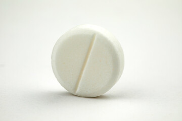 White round pill on white background. Health care concept.