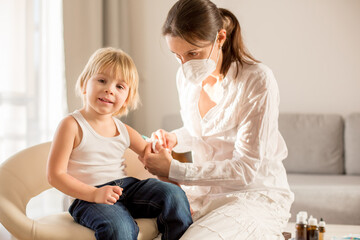 Little toddler boy, getting injection in consulting room from pediatrition