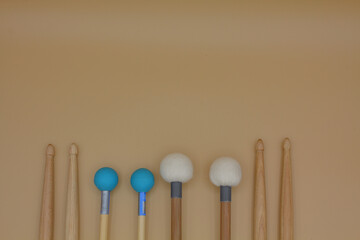 Percussion mallets set on a cream background.