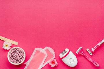 Cosmetics and means for epilation with flowers on pink background, flat lay