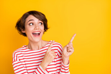 Photo of young beautiful happy smiling excited crazy girl pointing finger copyspace isolated on yellow color background