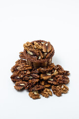 Peeled walnuts on a white background. A basket full of shelled walnuts. Nutritious food