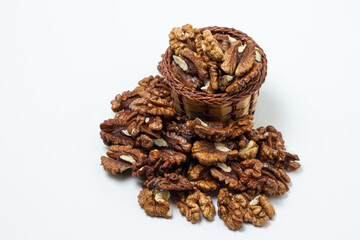 Peeled walnuts on a white background. A basket full of shelled walnuts. Nutritious food