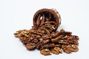 Peeled walnuts on a white background. Peeled walnuts spilled out of the basket. Nutritious food