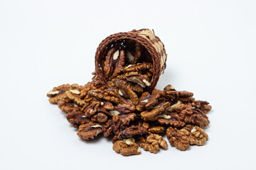 Peeled walnuts on a white background. Peeled walnuts spilled out of the basket. Nutritious food