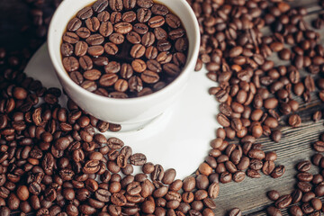 Hot drink in a saucer and sprinkled grain on a wooden table top view