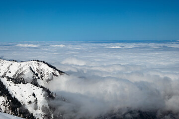Mountain winter landscape. Higher than clouds. Mostly cloudy. Almaty region. Tien Shan mountains. Kazakhstan