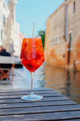 Glass of refreshing Aperol Spritz cocktail served on the deck bar in Venice. Traditional venetian...