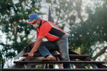 Carpenter making installation of roof structure  on a new gazebo construction project