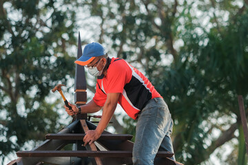 Carpenter making installation of roof structure  on a new gazebo construction project