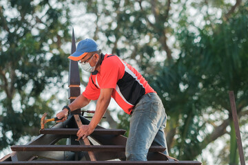 Carpenter making installation of roof structure  on a new gazebo construction project