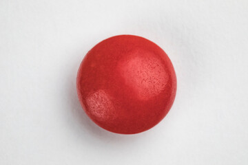 Red round pill on white background. Health care concept.