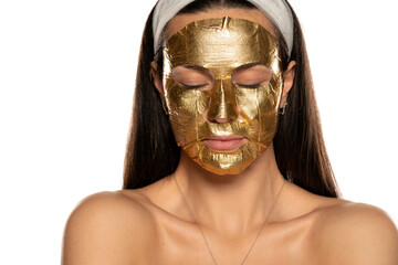young woman posing with golden mask on her face