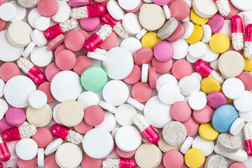 Background of assorted pharmaceutical capsules and medication in different colors.