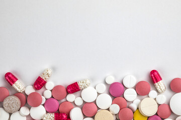 Background of assorted pharmaceutical capsules and medication in different colors.