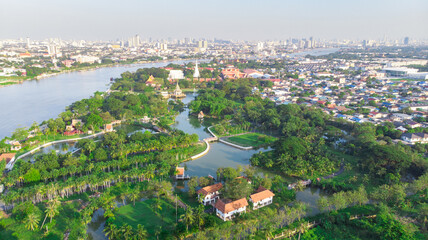 Aerial view of the park in bangkok with grass fields and tall skyscrapers surrounding the park.