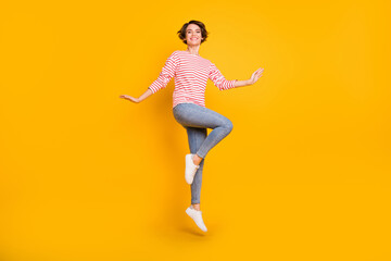 Fototapeta na wymiar Full size photo of young attractive lovely pretty cheerful smiling positive girl jumping isolated on yellow color background