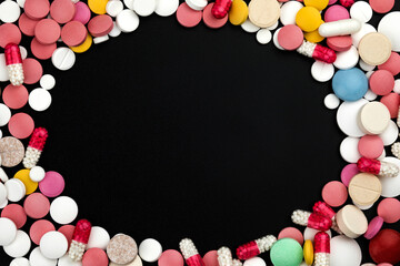 Background of assorted pharmaceutical capsules and medication in different colors.
