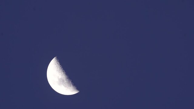 close up of a semi-circular moon at night. A half moon footage.
