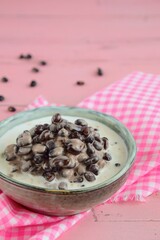 Black beans in coconut milk. Pink background