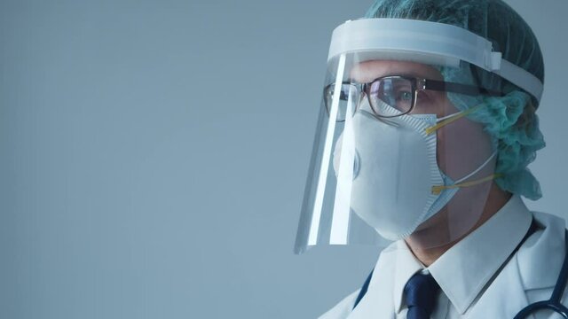 Studio portrait of young professional medical doctor in makk and protective visor. Infectious disease specialist. Covid-19 pandemic concept.