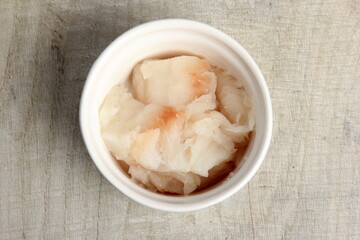 several dishes with raw fresh fish pieces before frying. dishes with unroasted julienne. Sliced white fish fillet in white pots 