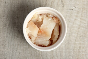 several dishes with raw fresh fish pieces before frying. dishes with unroasted julienne. Sliced white fish fillet in white pots 