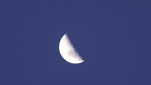 close up of a semi-circular moon at night. A half moon footage.
