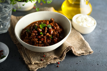 Homemade beef chili con carne with sour cream