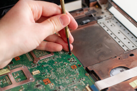 Man repearing a laptop circuit board. Laptop repair service.