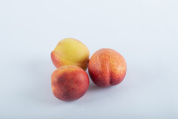Three fresh nectarines on a white background