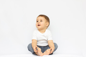 Cute little boy sitting isolated on white background. looking up concept.
