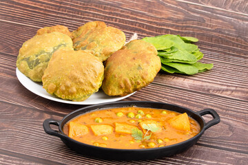 Favorite Indian Palak Poori Or Paalak Puri Made Of Wheat Flour Gehoon Ka Aata Mixed With Blenched Spinach Leaves Served With Alu Matar Sabzi Or Veg Curry Sabji. Wooden Background With Copy Space