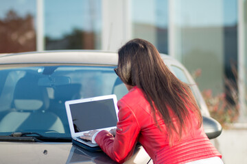 Woman using her laptop from her car
