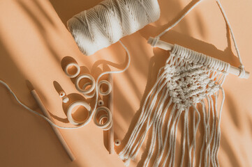 Macrame accessories on beige background. Creative hobby concept. Top view. Vintage color filter © Augustas Cetkauskas