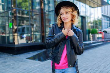  Close up  portrait of pensive   blonde short haired woman walking  on streets of big modern city.  Fashionable urban outfit