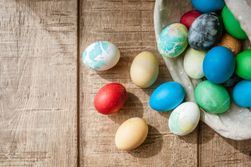 Basket with colored Easter eggs on brown wooden surface