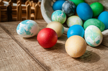 Fototapeta na wymiar Basket with colored Easter eggs on brown wooden surface