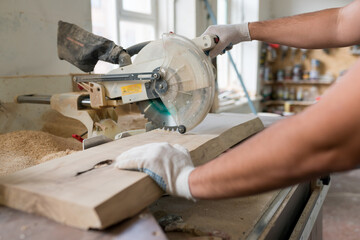 Carpenter working on wood with electric jigsaw in workshop. Joinery work on the production of wooden furniture. Small Business Concept