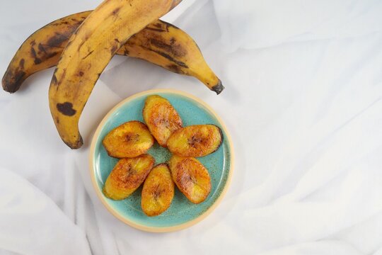 Fried slices of ripe plantains, traditional and popular snack in Central America and Northern South America. White background, text space