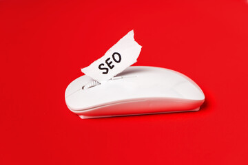 A piece of paper with an inscription SEO on the computer mouse. Search engine optimization of...